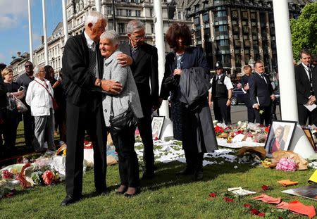 Gordon and Jean Leadbeater, parents of Labour MP Jo Cox who was killed outside her constituency surgery last week, embrace after viewing tributes to their daughter on Parliament Square, London, Britain, June 20, 2016. REUTERS/Stefan Wermuth