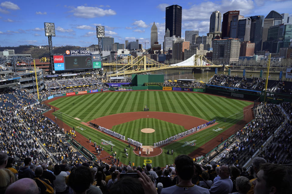 The Pittsburgh Pirates and the Chicago Cubs stand for the national anthem before the Pirates' home opener on April 12. (AP/Gene J. Puskar)