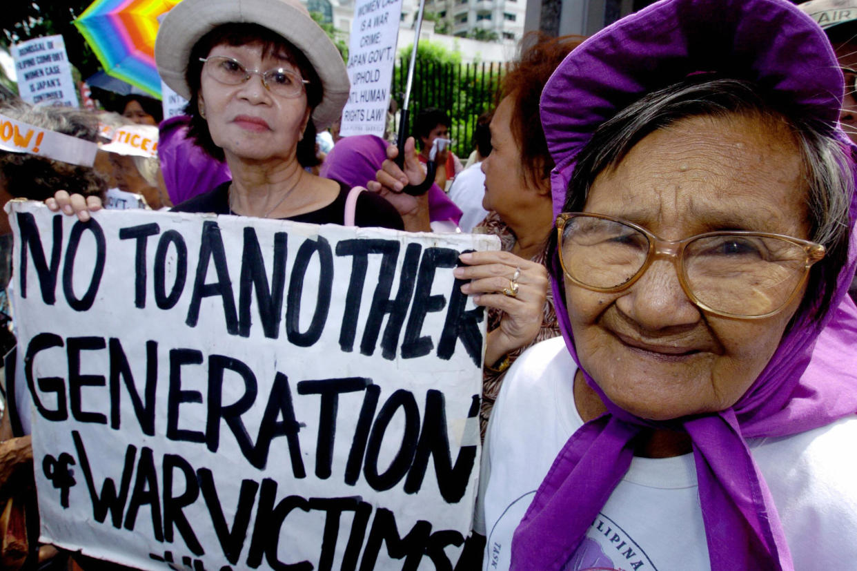 A Filipina comfort woman (R) and a supporter hold a protest in front of Japan Embassy in Manila, 13 August 2004, against the United States and Japan at the 59th anniversary of the end of World War II. (JAY DIRECTO/AFP via Getty Images)