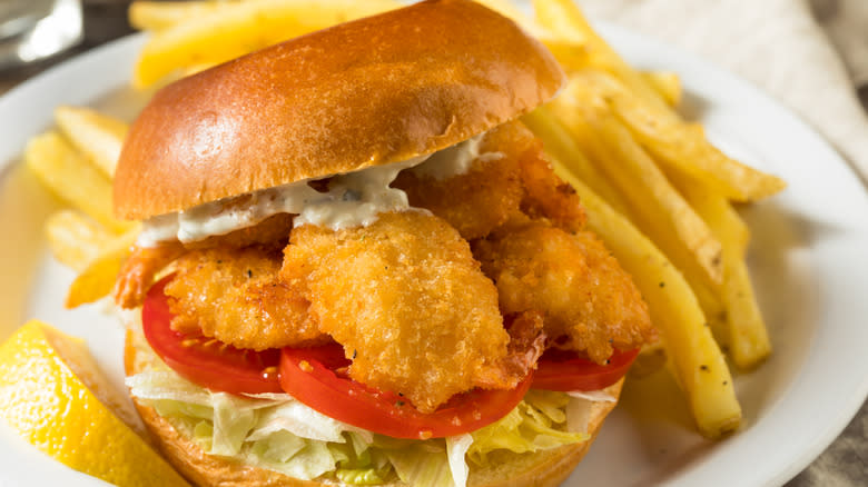 battered and fried artichoke sandwich with coleslaw on a brioche bun with french fries