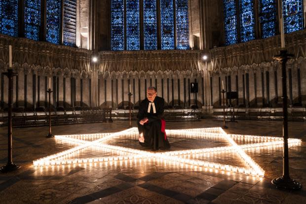 The Reverend Canon Michael Smith, Acting Dean of York, helps light six hundred candles in the shape of the Star of David, in memory of more than 6 million Jewish people murdered by the Nazis in the Second World War, in the Chapter House at York Minster