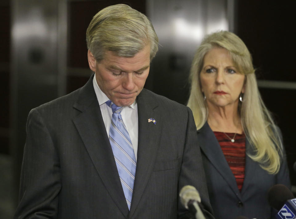 Former Virginia Governor Bob McDonnell takes a moment while making a statement as his wife, Maureen, right, looks on during a news conference in Richmond, Va., Tuesday, Jan. 21, 2014. McDonnell and his wife were indicted Tuesday on corruption charges after a monthslong federal investigation into gifts the Republican received from a political donor. (AP Photo/Steve Helber)