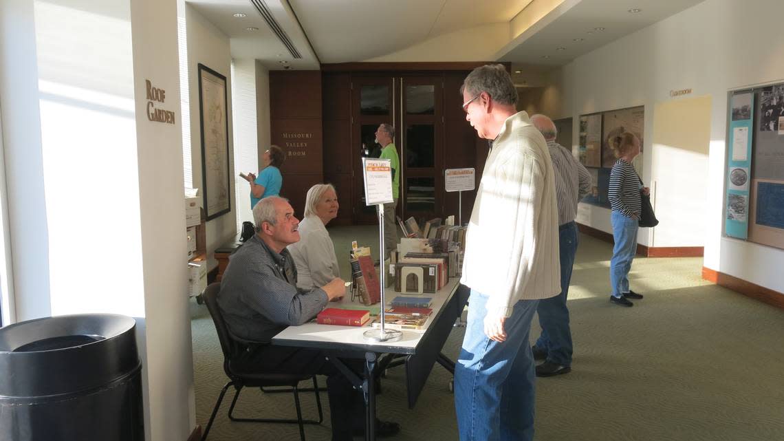 For Tom Pratt, seated at left, helping with book sales at author events is one of many volunteer duties.