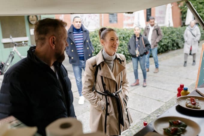 Customers Waiting In Line While People Order At Food Truck