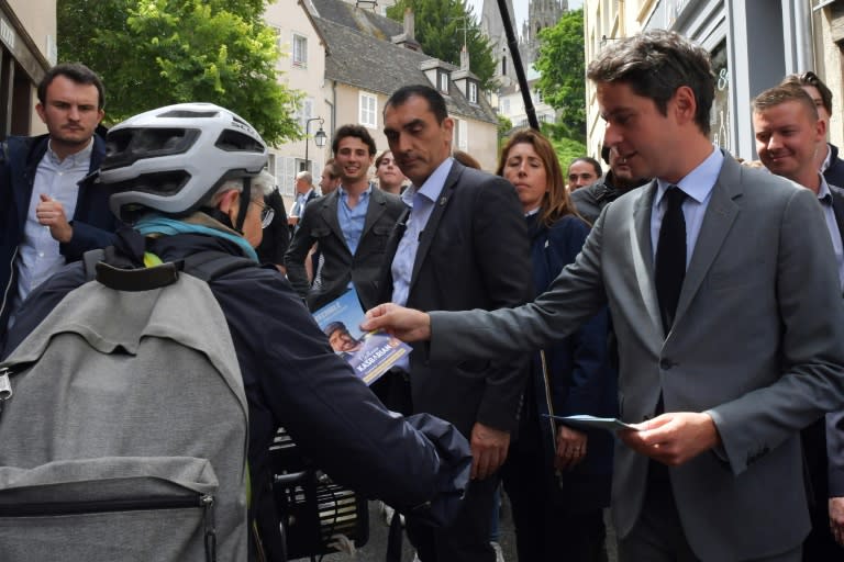 France's Prime Minister Gabriel Attal (R) distributes an election leaflet during a campaign visit in Chatres, centre France, on July 2, 2024, ahead of the second round of France's legislative elections (JEAN-FRANCOIS MONIER)