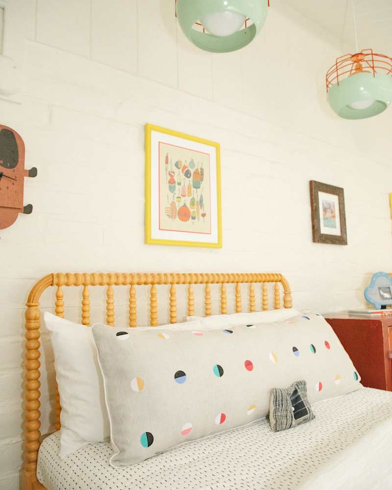 serene white kids room with muted color accents and light wood framed beds