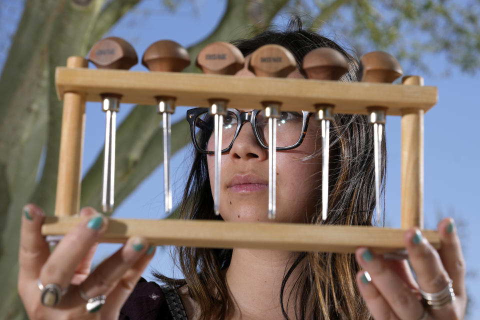 Olivia Yuen, 29, a middle school art teacher and well-known artist in Phoenix, who has a Chinese father and a Mexican mother, holds up carving tools for her linocut artwork Tuesday, May 21, 2024, in Laveen, Ariz. (AP Photo/Ross D. Franklin)