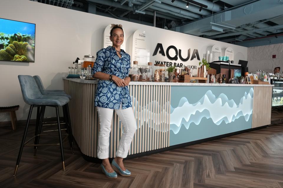 Roia Jabari, managing director of AQUA Water Bar by LUQEL poses at her store in Dubai, United Arab Emirates, Tuesday, July 11, 2023. Dubai's gourmet water bar joins a growing list of unique businesses that have sprouted out of the uninterrupted stretches of windblown sand dunes turned into a bustling desert metropolis, complete with the world's tallest building, cavernous malls, and palm-shaped man-made islands.(AP Photo/Kamran Jebreili)