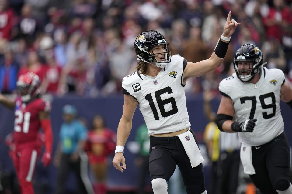 Jacksonville Jaguars quarterback Trevor Lawrence (16) and Luke Fortner (79) celebrate after Lawrence carried the ball for a touchdown in the first half of an NFL football game against the Jacksonville Jaguars in Houston, Sunday, Nov. 26, 2023. (AP Photo/Eric Gay)