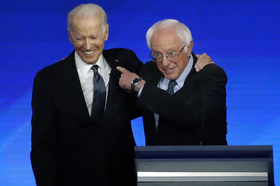 FILE - Former Vice President Joe Biden, left, embraces Sen. Bernie Sanders, I-Vt., during a Democratic presidential primary debate, Feb. 7, 2020, hosted by ABC News, Apple News, and WMUR-TV at Saint Anselm College in Manchester, N.H. (AP Photo/Elise Amendola, File)