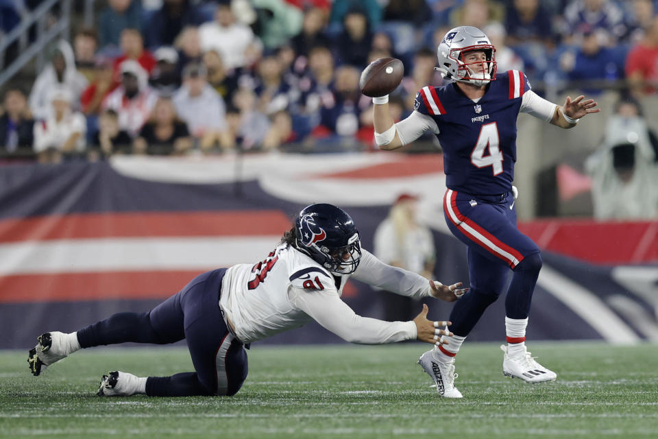 Houston Texans defensive tackle Roy Lopez, left, reaches for New England Patriots quarterback Bailey Zappe (4) during the first half of an NFL preseason football game Thursday, Aug. 10, 2023, in Foxborough, Mass. (AP Photo/Michael Dwyer)