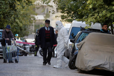 A forensics officer exits a building following an operation in which Greek security services raided Athens apartments and found bomb-making equipment, detaining nine people on suspected links to a leftist militant group outlawed in Turkey in Athens, Greece, November 28, 2017. REUTERS/Alkis Konstantinidis