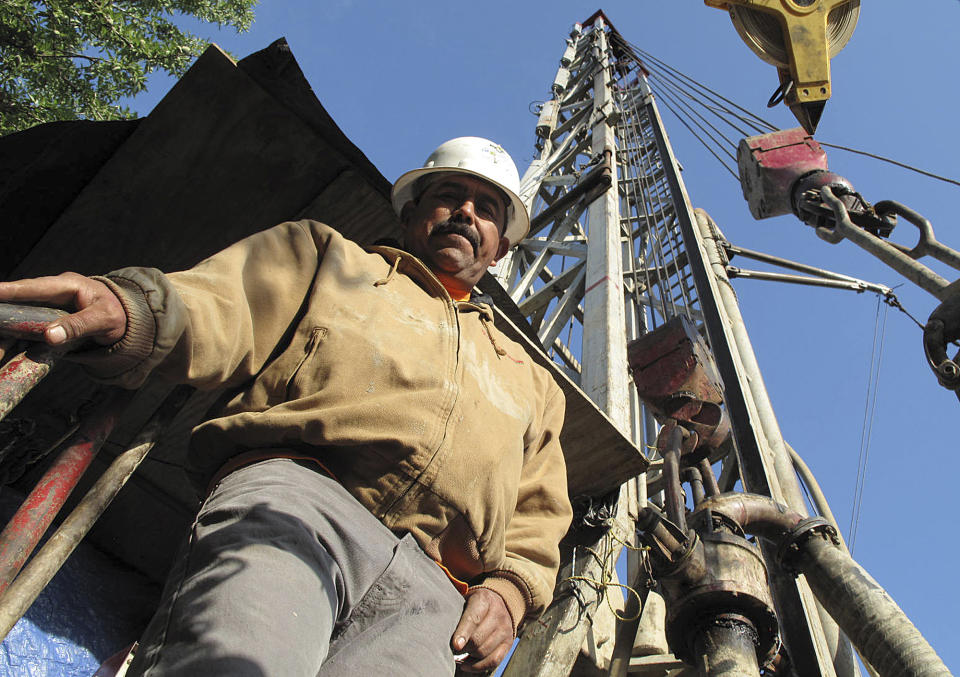 Jorge Vargas, a foreman for Maggiora Brothers Drilling Inc., poses for a photograph while drilling an 800-foot-deep water well at an almond farm in Chowchilla, Calif., on Friday, April 4, 2014. In California’s drought, well drillers are experiencing a boom in business because farmers are relying more on ground water to irrigate their crops. (AP Photo/Scott Smith)