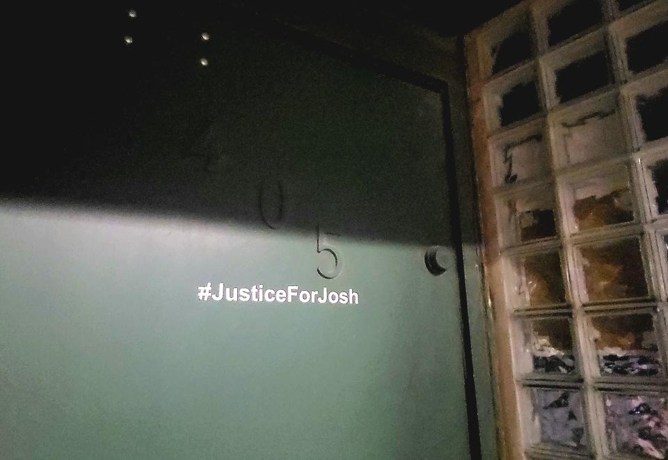 Light shines on a #JusticeForJosh decal tagged on the door of the Roche Bar, 405 Quay St., on Thursday, Dec. 7, 2023, in downtown Port Huron. Joshua Conant was killed nearby the establishment Nov. 4.