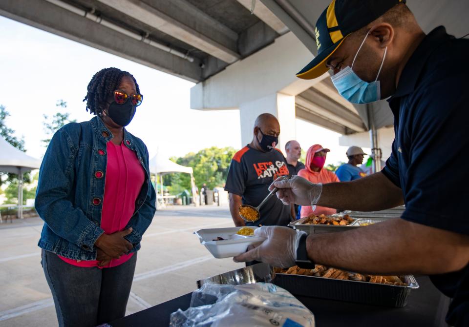 Carla King Richardson waits for cheese to be added to her grits during the sunrise brunch offered during the final day of the Inaugural Soul of  Southside Festival on Saturday, May 22, 2021.