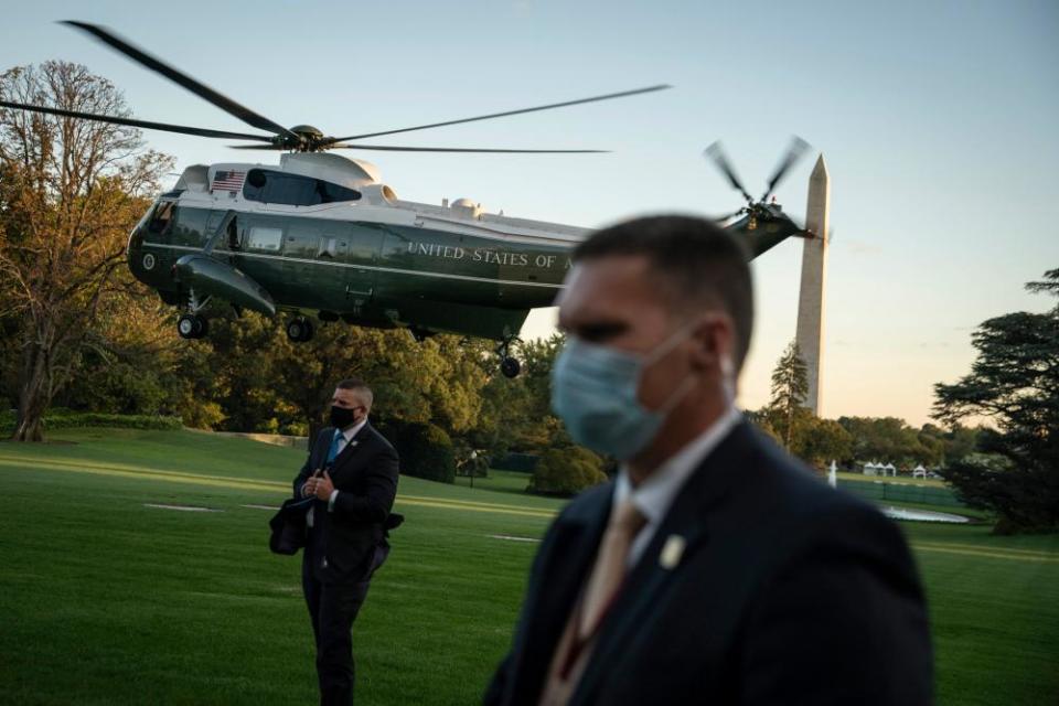 Secret Service agents standby as Donald Trump departs from the South Lawn.