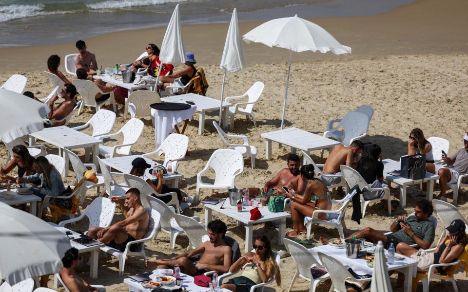 People rest on the beach in Tel Aviv