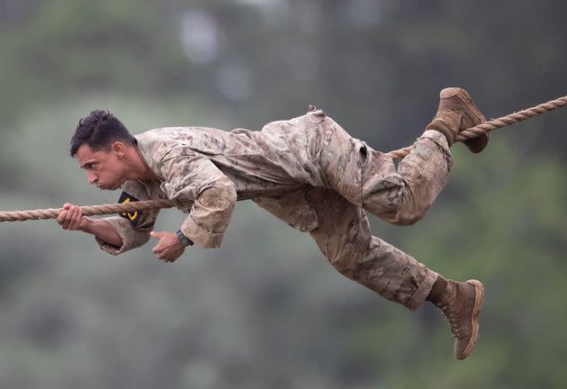 An Army Ranger crawls across a rope stretched over Victory Pond during the combat water skills portion of a Best Ranger competition in 2019 at Fort Benning.