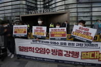 Members of youth groups hold banners to denounce the Japan government's decision on Fukushima water, in Seoul, South Korea, Tuesday, April 13, 2021. Japan's government decided Tuesday to start releasing massive amounts of treated radioactive water from the wrecked Fukushima nuclear plant into the Pacific Ocean in two years - an option fiercely opposed by local fishermen and residents. The Korean letters read: "Denounce, Prime Minister Yoshihide Suga." (AP Photo/Lee Jin-man)