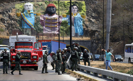 Security forces block the road as they clash with lawmaker members of the Venezuelan National Assembly and supporters of the Venezuelan opposition leader Juan Guaido, who many nations have recognised as the country's rightful interim ruler, on the outskirts of Mariara, Venezuela February 21, 2019. REUTERS/Andres Martinez Casares