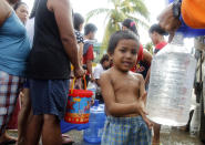 A boy fills up a plastic bottle with water after super typhoon Haiyan hit Tacloban city, central Philippines November 11, 2013.