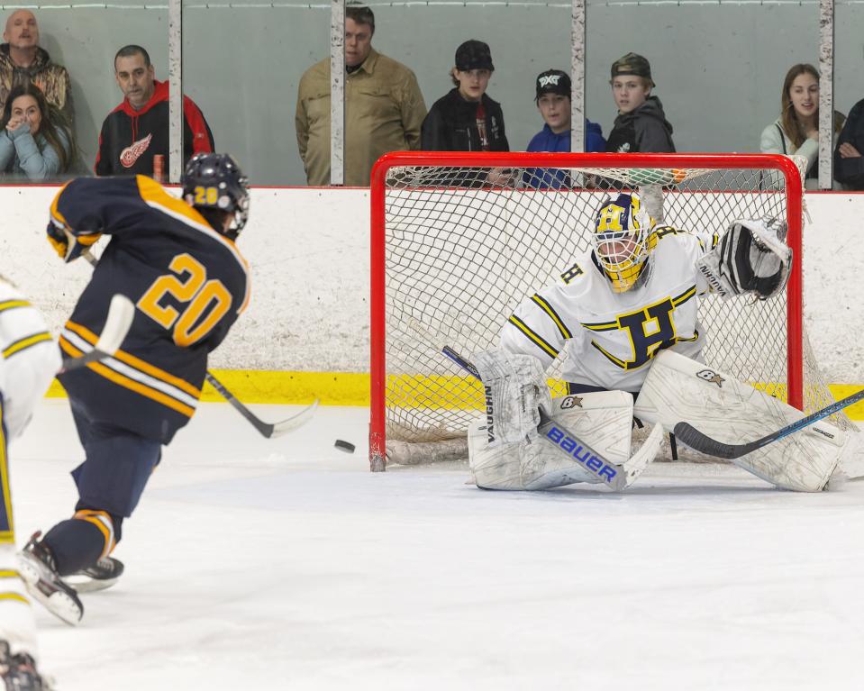 Hartland goalie Colin Babcock prepares to stop a shot by Clarkston's Devon Collis during the Eagles' 6-1 victory in the regional championship game Wednesday, March 1, 2023.