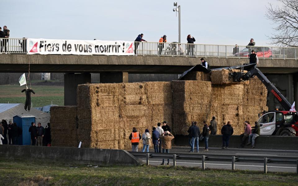 A banner reading "Proud to feed you !" raised at a road block by farmersA banner reading "Proud to feed you!" raised at a road block by farmers on the A4 highway near Paris on the A4 highway near Paris