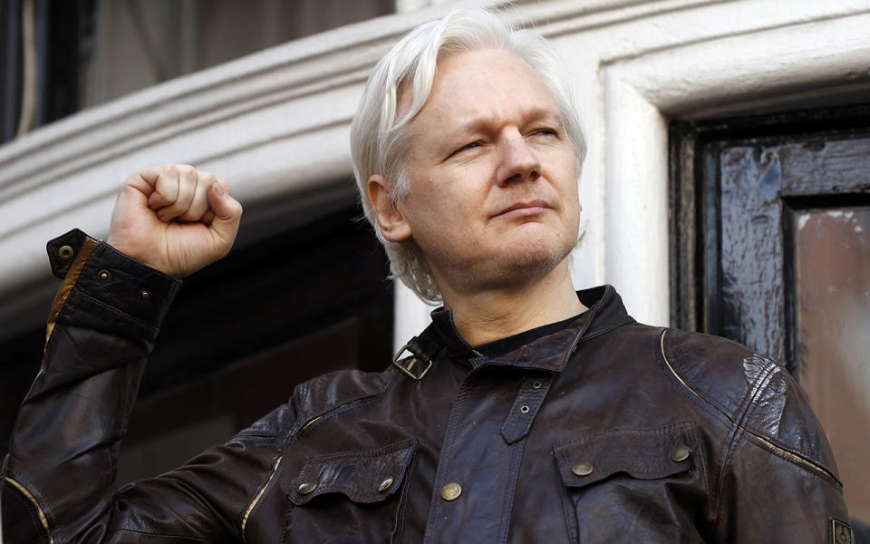 Julian Assange raises a fist. Source: AP