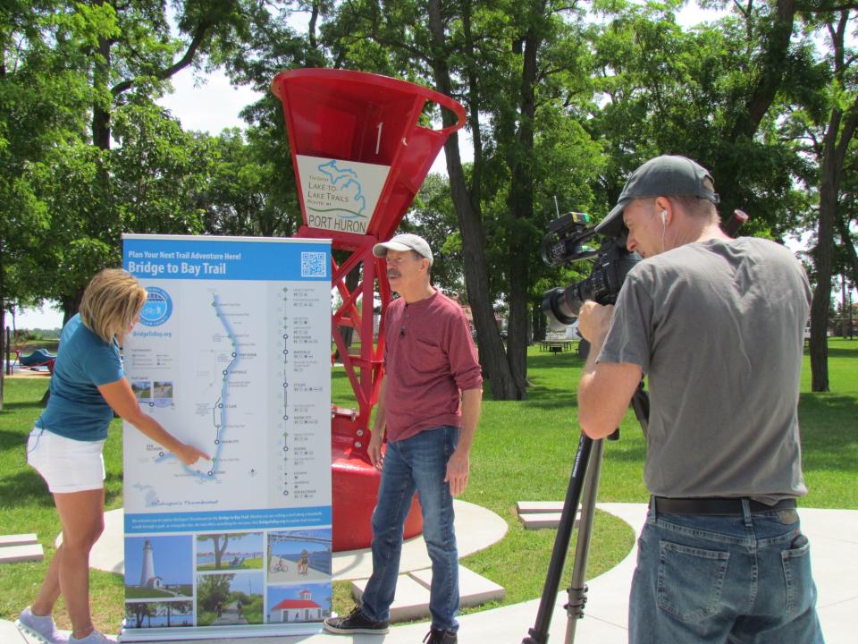 Sheri Faust, left, and Tom Daldin, right, filming a segment for the Port Huron episode of "Under the Radar" on July 12, 2023. Faust talked about the Bridge to Bay Trail and Fort Gratiot Lighthouse for the episode.