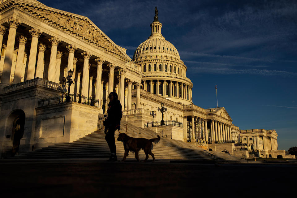 The US Capitol building is seen as a woman and her dog walk past it on Nov. 8, 2022, in Washington, DC.