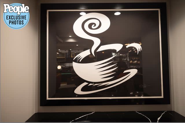 <p>Brian Nevins</p> An oversized piece depicting a cup and saucer by pop artist Burton Morris, who had artwork on the original set, hangs above one nook.