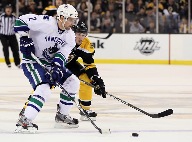 BOSTON, MA - JANUARY 07: Dan Hamhuis #2 of the Vancouver Canucks tries to keep the puck from Brad Marchand #63 of the Boston Bruins on January 7, 2012 at TD Garden in Boston, Massachusetts. (Photo by Elsa/Getty Images)