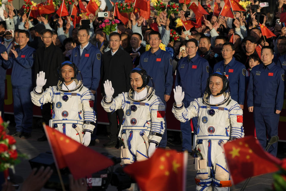 Los astronautas chinos de la misión Shenzhou-17, (de izquierda a derecha) Jiang Xinlin, Tang Hongbo y Tang Shengjiem saludan durante la ceremonia de despedida de su misión tripulada en el centro de lanzamiento de satélites de Jiuquan, en el noroeste de China, el 26 de octubre de 2023. (AP Foto/Andy Wong)