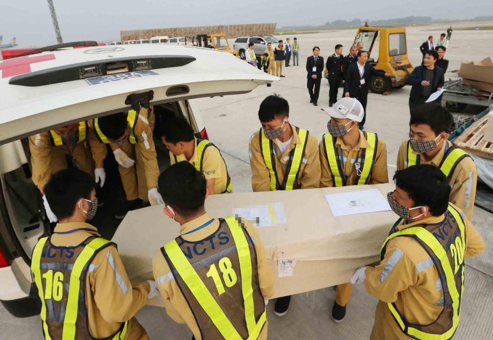 Officials move coffins containing the victims at Noi Bai International Airport in Hanoi in November 2019 (EPA)