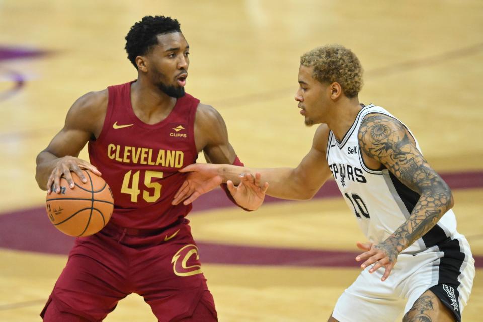 Jan 7, 2024; Cleveland, Ohio, USA; Cleveland Cavaliers guard Donovan Mitchell (45) dribbles beside San Antonio Spurs forward Jeremy Sochan (10) in the first quarter at Rocket Mortgage FieldHouse. Mandatory Credit: David Richard-USA TODAY Sports