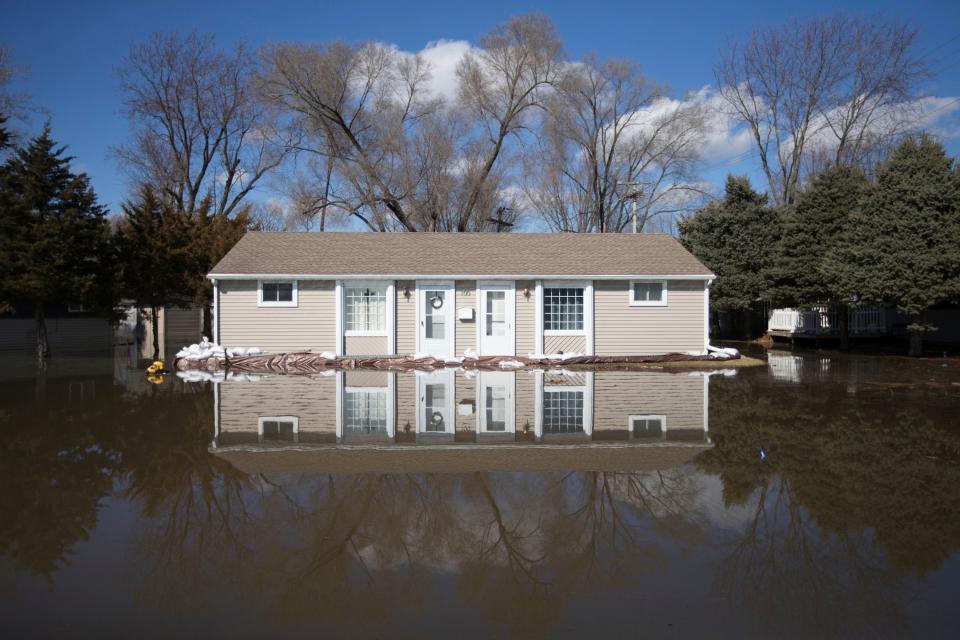 The Rock River crested its banks and floods a home on Old Harlem Road on Saturday, March 16, 2019, in Machesney Park, Ill.