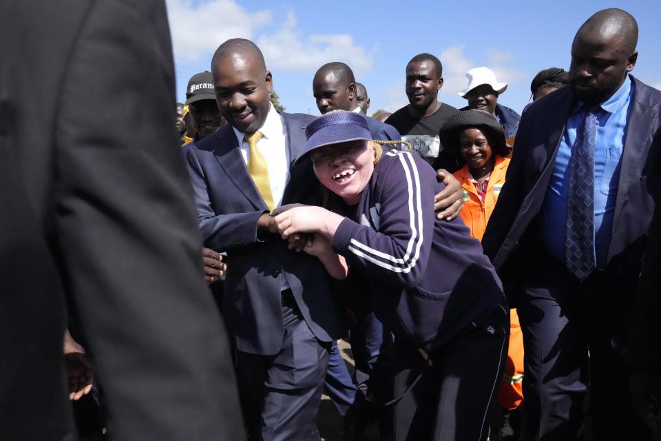 Zimbabwe's main opposition leader, Nelson Chamisa, left, greets a supporter after he had inspected the voters roll in Harare, on Tuesday, May, 30, 2023. Chamisa described the voters roll as "a perennial challenge" and alleged that irregularities include missing names of registered voters as the country prepares for elections to be held on Aug.23. (AP Photo/Tsvangirayi Mukwazhi)