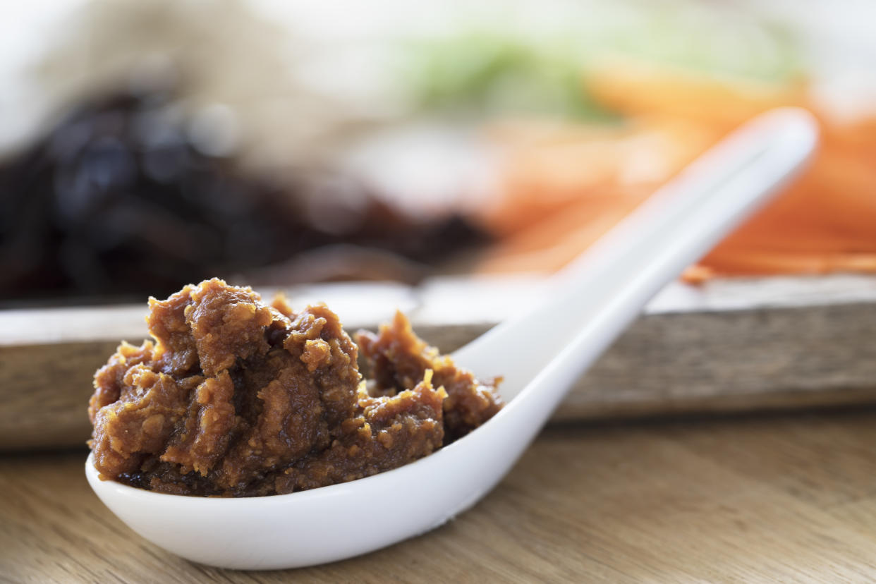 Close up of red miso paste in a Chinese soup spoon.