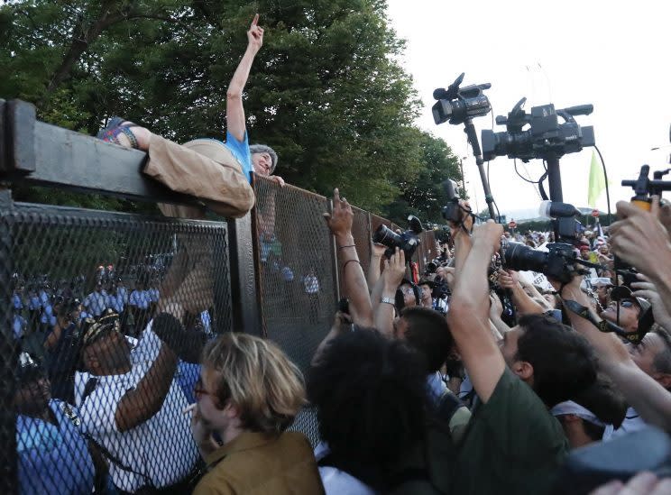 A protester climbs over the fence on the second day of the Democratic National Convention. (Alex Brandon/AP)