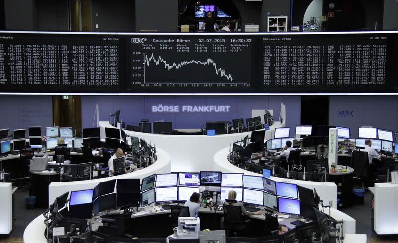 Traders are pictured at their desks in front of the DAX board at the Frankfurt stock exchange July 2, 2015. REUTERS/Remote/Staff