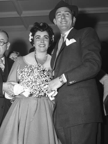 <p>Bettmann</p> Elizabeth Taylor and Michael Wilding pose for cameras following their marriage on February 21, 1952.