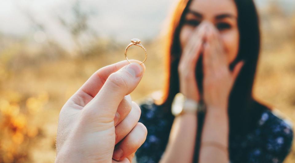 woman with hands in front of face looking at ring