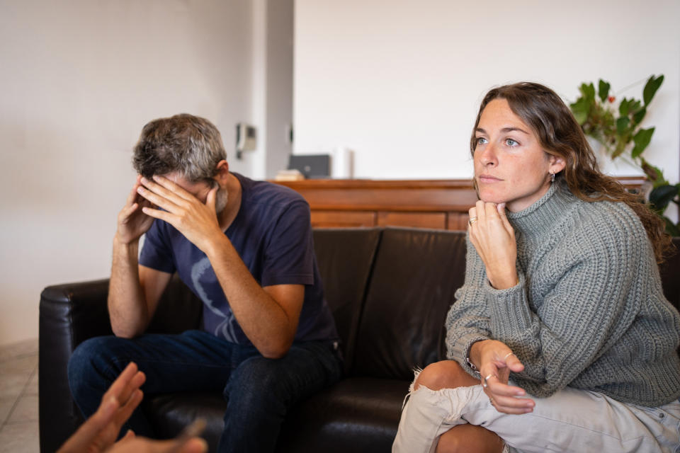 Man doing a desperate gesture hidding his face during couple's therapy with a psychologist