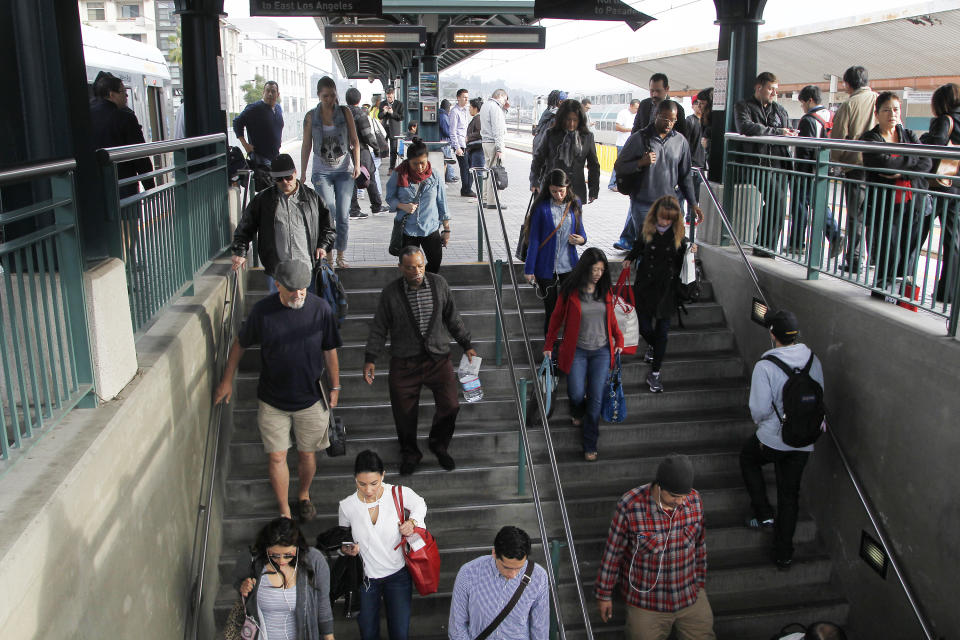 Pedestrians prepare to board a train at Union Station Friday March 7, 2014 in Los Angeles. Americans are boarding public buses, trains and subways in greater numbers than any time since the suburbs began to boom. Nearly 10.7 billion trips in 2013, to be precise, the highest number since 1956. (AP Photo/Nick Ut)