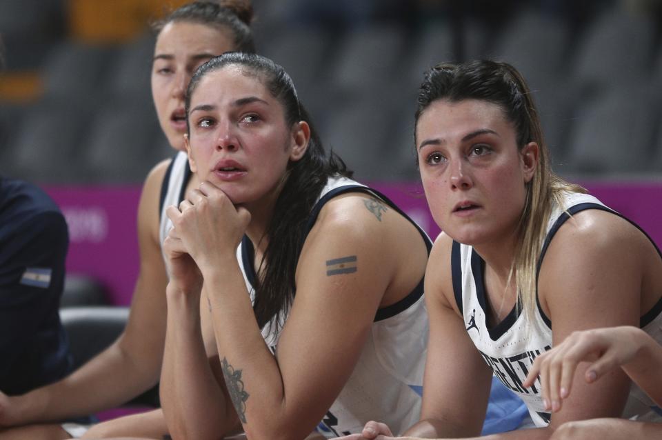 ADDS REASON WHY ARGENTINA IS OUT OF THE MEDAL ROUND - Argentina's players watch the women's basketball match against the Virgin Islands from the bench, at the Pan American Games in Lima, Peru, Thursday, Aug. 8, 2019. Argentina's women's basketball team had to forfeit its match against Colombia at the Pan American Games on Wednesday for wearing the wrong uniform color. Argentina won today’s match against the Virgin Islands but is out of the medal rounds because of the uniform blunder. (AP Photo/Martin Mejia)