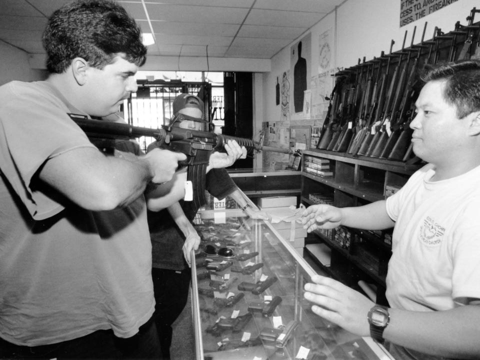 A civilian tries out an AR-15 at a gun shop in 1993.