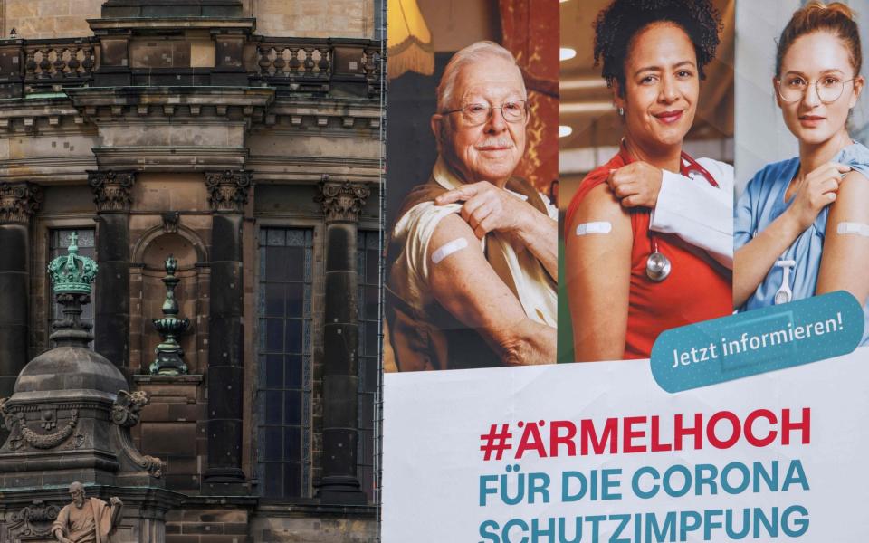 A giant billboard calling for people to get vaccinated which reads 'Roll up your sleeves for the corona vaccine', hangs on the facade of the Cathedral in Berlin's Mitte district  - AFP