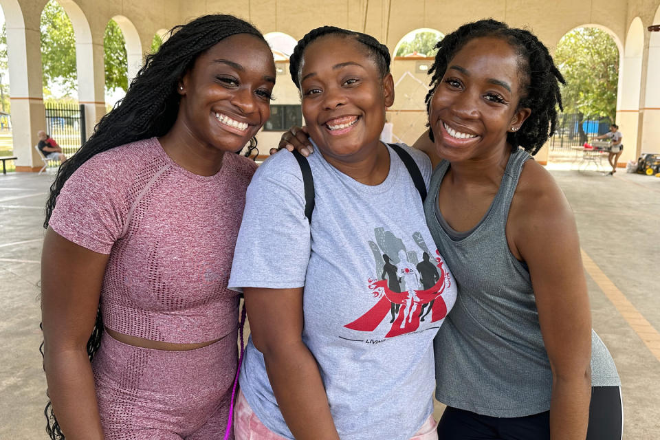 Quannecia McCruse stands between two of her friends, Faith Adjei-Sarpong, left, and Precious Uwaezuoke, at the Sickle Cell Houston Walk in September
2023. (Alex Arvie)