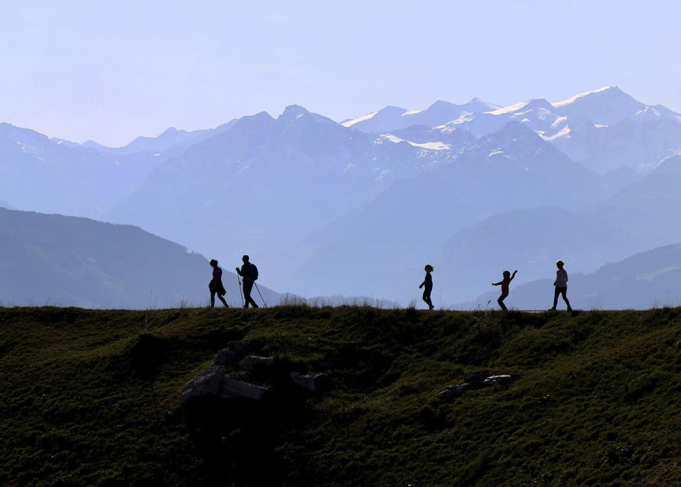 People make their way from the 'Kitzbuehler Horn' mountain (1,996 meters) at the alps near Kitzbuehl, Austria, Sunday, Oct. 27, 2019.(AP Photo/Matthias Schrader)