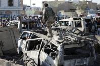 A Houthi fighter walks on a vehicle damaged by an air strike at a residential area near Sanaa Airport March 26, 2015. REUTERS/Khaled Abdullah